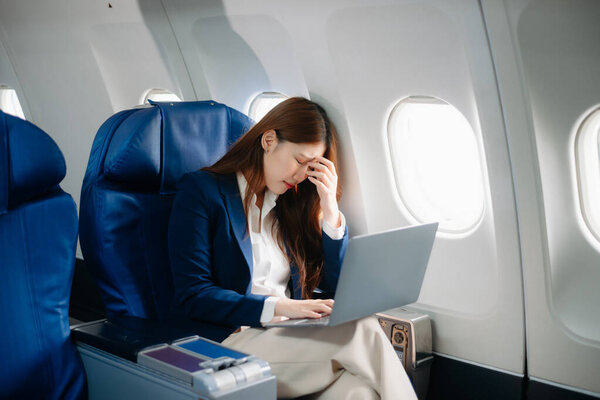 Азиатская женщина, сидящая в кресле в самолете и глядя в окно собирается в поездку туристической концепции
