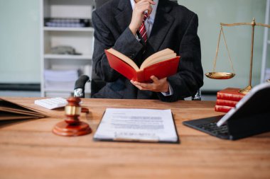 Adalet ve hukuk kavramı. Beyaz masadaki bir mahkeme salonunda erkek yargıç ve ofiste çalışan avukat veya erkek avukat..