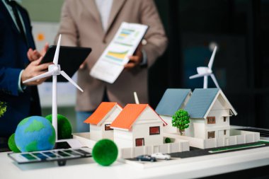 Emlak komisyoncusu, emlak kredisi teklifiyle ilgili sözleşme imzalama anlaşmasını, ev modelini sunar ve müşteriye danışmanlık yapar.