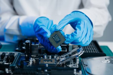 Teknisyen işlemciyi ana bilgisayarın prizine yerleştiriyor. Elektronik mühendislik, elektronik onarım, elektronik ölçüm ve test, onarım.