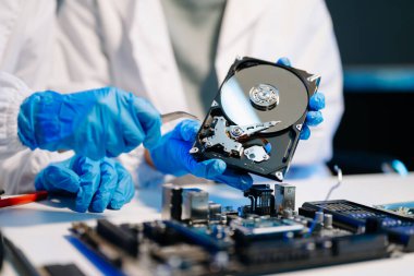  Teknisyenin masasında sabit disk ve bir bilgisayar ana kartı var. Veri, donanım ve bilgi teknolojisi kavramı.