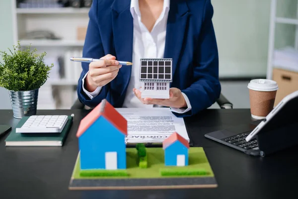 Emlak sektörünü dengelemek için emlakçı ev tasarımını ve satın alma anlaşmasını görmek için ev tarzını açıklıyor. Ofiste model ev ve komdo.