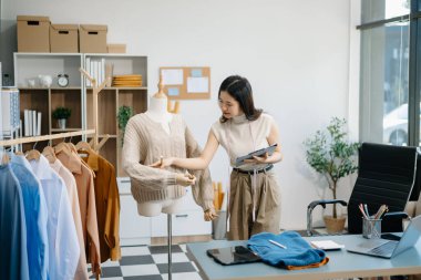 Güzel Asyalı kadın blogcu, video kaydına kamera önünde kıyafetlerini gösteriyor. 