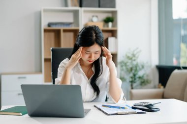 Frustrated young businesswoman working on a laptop computer sitting at his working place in offic