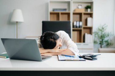 Frustrated young businesswoman working on a laptop computer sitting at his working place in offic