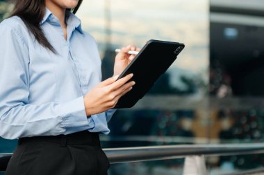 İş kadını cep telefonu, tablet kullanıyor. Bulanık grupta yakın plan.