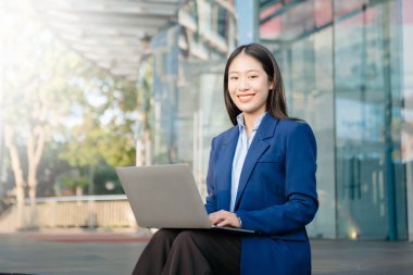  Çalışan kadın konsepti. Video konferansına katılan ve elinde tablet tutan bir kadın menajer. Şehir dışındaki caddede akıllı telefon.