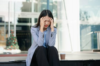 Asyalı iş kadını stresli, sıkılmış ve tablet üzerinde çalıştığı için aşırı düşünüyor. 