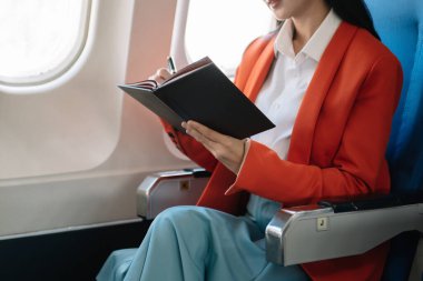 İş kadını ön tablette oturuyor, bilgisayarında mali grafikler ve istatistikler var.