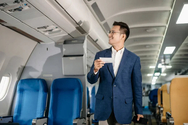 Genç Asyalı yönetici, dijital tablet, dizüstü bilgisayar ve akıllı telefondan birden fazla iş yaparak birinci sınıfta başarılı oluyor. Stil içinde seyahat et, zarafetle çalış.