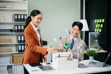 Daha yeşil bir gelecek için genç profesyoneller tarafından sürdürülebilir bir yenilik. Güneş panelleri, rüzgar türbinleri ve bir model ev ile yenilenebilir enerji çözümleri gösteriliyor. 