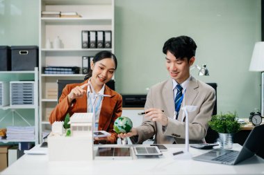 Daha yeşil bir gelecek için genç profesyoneller tarafından sürdürülebilir bir yenilik. Güneş panelleri, rüzgar türbinleri ve bir model ev ile yenilenebilir enerji çözümleri gösteriliyor. 