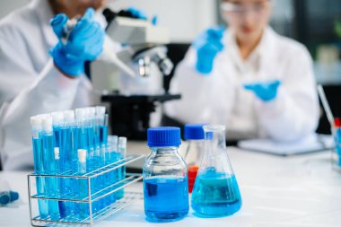 Asyalı kadın bilim adamları modern laboratuarda kimya araştırması yapıyorlar.