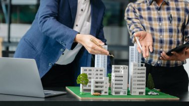 Emlak sektörünü dengelemek için emlakçı ev tasarımını ve satın alma anlaşmasını görmek için ev tarzını açıklıyor. Ofisteki ev