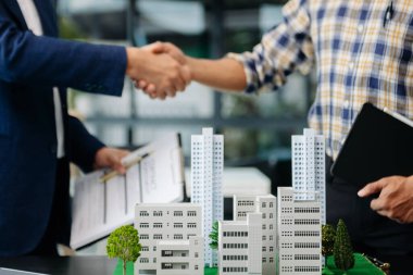 Emlak sektörünü dengelemek için emlakçı ev tasarımını ve satın alma anlaşmasını görmek için ev tarzını açıklıyor. Ofisteki ev