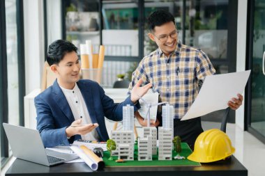 Mühendis Takım Çalışması Toplantısı, Çizim Şirket Ofisi 'ndeki model binasında ortakla birlikte çalışarak proje planı toplantısı üzerinde çalışıyor. Asya endüstrisi profesyonel çayı