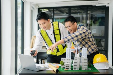 Mühendis Takım Çalışması Toplantısı, Çizim Şirket Ofisi 'ndeki model binasında ortakla birlikte çalışarak proje planı toplantısı üzerinde çalışıyor. Asya endüstrisi profesyonel çayı