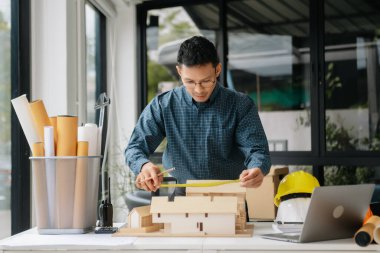Erkek mimar elleri model ev yapıyor. Modern ofiste çalışan mimar adam..