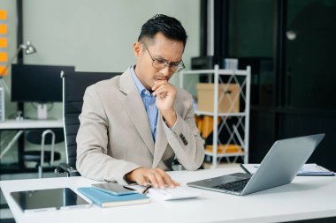  Masaya dizüstü bilgisayar ve tablet yerleştiren Asyalı işadamı 