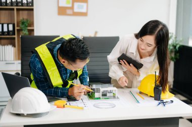 Mühendis Takım Çalışması Toplantısı, Çizim Şirket Ofisi 'ndeki model binasında ortakla birlikte çalışarak proje planı toplantısı üzerinde çalışıyor. Asya endüstrisi profesyonel çayı