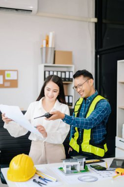 Mühendis Takım Çalışması Toplantısı, Çizim Şirket Ofisi 'ndeki model binasında ortakla birlikte çalışarak proje planı toplantısı üzerinde çalışıyor. Asya endüstrisi profesyonel çayı