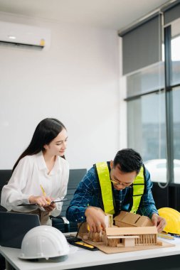 Mühendis Takım Çalışması Toplantısı, Çizim Şirket Ofisi 'ndeki model binasında ortakla birlikte çalışarak proje planı toplantısı üzerinde çalışıyor. Asya endüstrisi profesyonel çayı