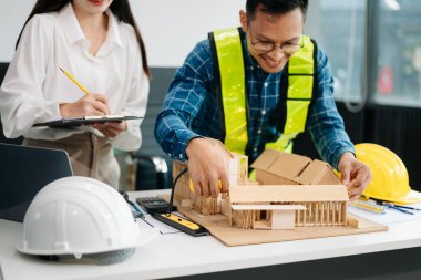 Mühendis Takım Çalışması Toplantısı, Çizim Şirket Ofisi 'ndeki model binasında ortakla birlikte çalışarak proje planı toplantısı üzerinde çalışıyor. Asya endüstrisi profesyonel çayı