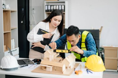 Modern ofisteki inşaat sahasında mimari projeyle büyük çizimlere yansıyan yaratıcı mimar