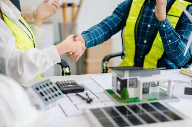 İş adamlarının şirket ofisinde rüzgar enerjisi hakkında görüşleri var. Mimari proje sitesinde ve model ev yapımında. Asya endüstrisi profesyonel 