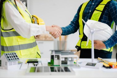 Engineer and contractor join hands after signing contract,They are having a modern building project together. successful cooperation concep