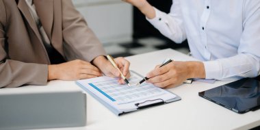 İş arkadaşları birlikte çalışıyor, tartışıyorlar ve ofiste tablet ve dizüstü bilgisayar kullanıyorlar.