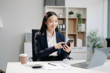 Güzel Asyalı kadın çalıştığı yerde bilgisayarını ve tabletini kullanıyor. İşine odaklan..