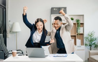 Ofiste yeni bir proje üzerinde çalışırken mutlu iş adamları. Ofiste bir dizüstü bilgisayar ve tablet kullanan çeşitli iş adamları.