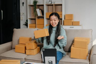 Güzel Asyalı kadın blogcu, video kaydına kamera önünde kıyafetlerini gösteriyor. 