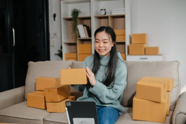 Güzel Asyalı kadın blogcu, video kaydına kamera önünde kıyafetlerini gösteriyor. 