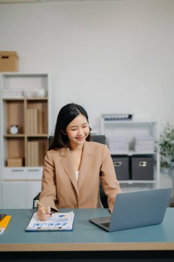 Kendine güvenen iş uzmanı çekici, gülümseyen genç bir kadın yaratıcı ofiste elinde dijital tablet tutuyor..
