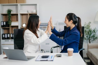Bayan meslektaşımla yeni projeyi tartışıyoruz. Genç kadınlar modern ofiste genç Asyalı bir adamla konuşuyorlar..
