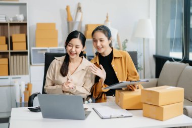 Starting small businesses SME owners, two check online orders Selling products working with boxs freelance work at home office using tablet and laptop  marketing, packaging, concept