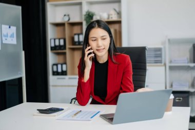 Modern ofiste gülümseyen genç ve çekici Asyalı ofis çalışanı takım elbiseleri.