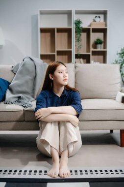 Asyalı kadın Buhran 'da oturur. Koyu saçlı, dalgın bakışlı. Pencere ve anksiyete dolu. Hastalık, sağlık ve iyileşme kavramı. 