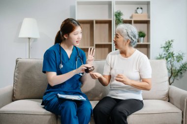 Asyalı bakıcı doktor yaşlı hasta kadın terapisti muayene ediyor. Huzurevinde yaşlı yaşlı bir kadınla ilgileniyor. Hastane konsepti üzerine oturuyor. Yardım etmek ve teşvik etmek