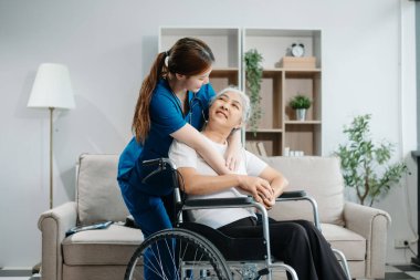 Asyalı bakıcı doktor yaşlı hasta kadın terapisti muayene ediyor. Huzurevinde yaşlı yaşlı bir kadınla ilgileniyor. Hastane konsepti üzerine oturuyor. Yardım etmek ve teşvik etmek