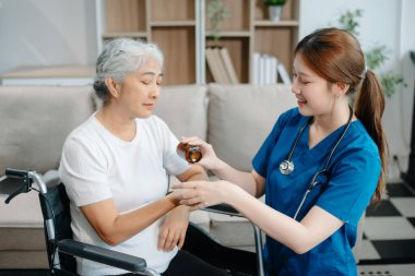 Asyalı bakıcı doktor yaşlı hasta kadın terapisti muayene ediyor. Huzurevinde yaşlı yaşlı bir kadınla ilgileniyor. Hastane konsepti üzerine oturuyor. Yardım etmek ve teşvik etmek