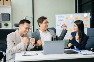 Genç Asyalı iş adamlarından oluşan bir grup yaratıcı iş adamı, takım çalışması başarıyı kutluyor ve ofisin yaratıcı tasarımını planlıyor.