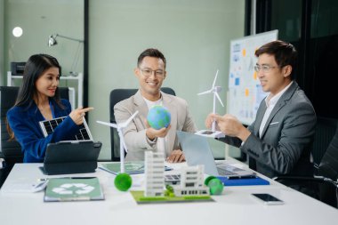 Neare 'de oturan çeşitli etnik çeşitlilikteki işadamları, konut projesinden bir yapı modeline bakıyorlar. Yeşil iş şirketi ve Güneş Enerjisi Çevre Kenti Kavramı.