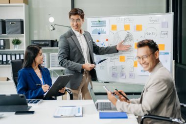 Ofisteki iş arkadaşları gündelik bir konuşma yapıyorlar. Bir konferans odasında bir grup Asyalı iş adamı konferans odasında yeni bir proje üzerinde oturuyorlar..