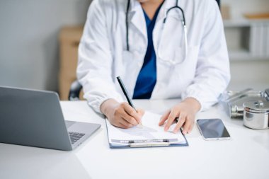 Tıbbi teknoloji konsepti. Modern ofiste cep telefonu ve steteskopla çalışan bir doktor.