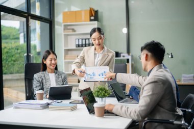 Yaratıcılık sektöründe tasarım planlama konusunda bir grup Asyalı iş toplantısı ofiste iş tartışması