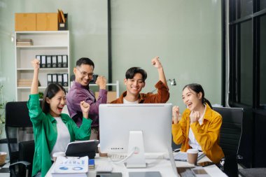 Modern bir ofiste Asyalı profesyoneller arasındaki takım çalışması ve işbirliği, kurumsal kültür, yenilik ve verimliliği gözler önüne seriyor