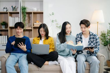 Bir grup genç Asyalı üniversite öğrencisi, dizüstü bilgisayar ve tablet kullanarak onun proje ödevi üzerinde çalışıyorlar. Birlikte, konuşmanın ve evde atıştırmanın tadını çıkarın.